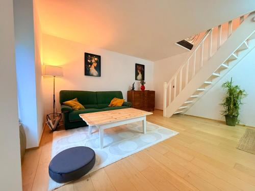 a living room with a green couch and a table at Apartment 6 prsn avec Terrasse Proche Centre-ville in Besançon