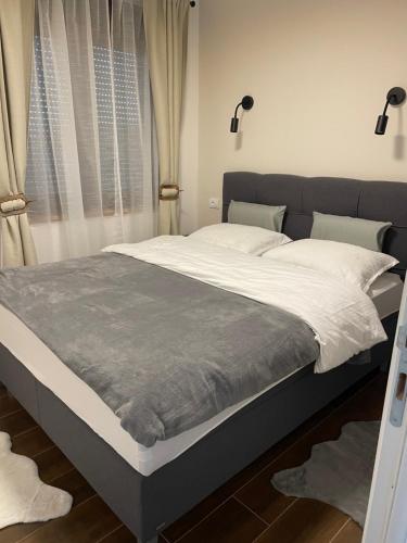 a bedroom with a large bed with white sheets at Jelena Lux Apartmani - Zlatibor - Tornik in Čajetina