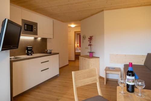 a kitchen with a table with wine glasses on it at Residence Viktoria in Castelrotto