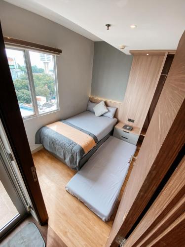 a small room with a bed and a window at 2BR Apartement Sudirman Bandung in Bandung
