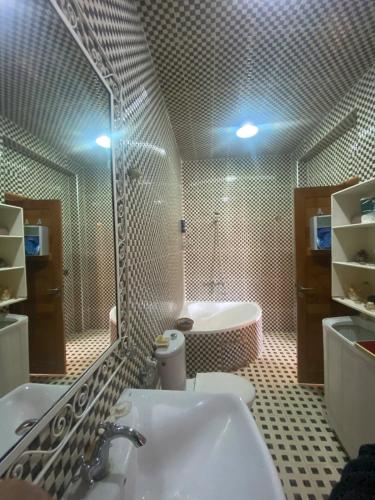 une salle de bain avec une baignoire, un lavabo et un miroir dans l'établissement Luxury Apartment Meknes, à Meknès
