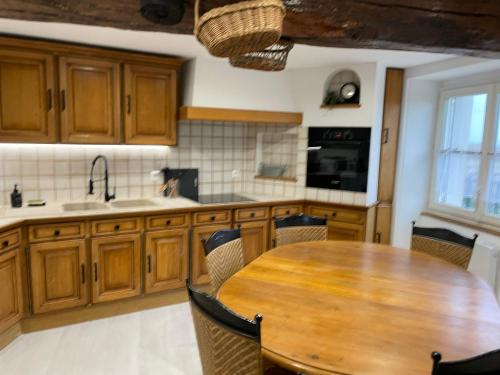 - une cuisine avec une table en bois, des chaises et un évier dans l'établissement La Cristalline, à Turquant