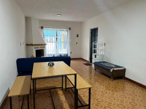 a living room with a blue couch and a table at Departamento Río Verde in San Cristóbal de Las Casas