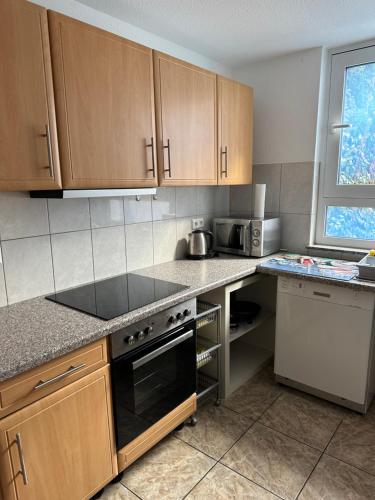 a kitchen with wooden cabinets and a stove top oven at BK City Apartments in Winnenden