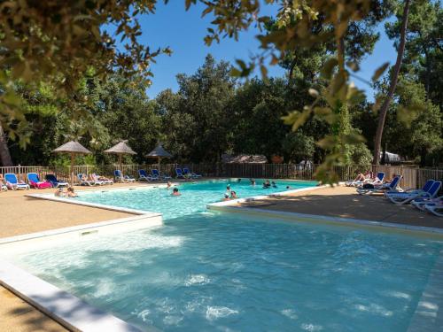 a pool at a resort with people in the water at Domaine Résidentiel de Plein Air Monplaisir in Saint-Trojan-les-Bains