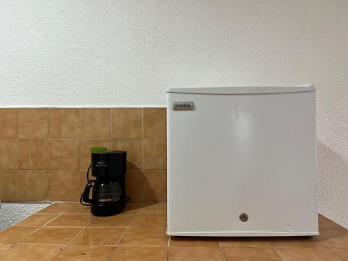 a white refrigerator sitting in a room next to a wall at Departamento Río Verde in San Cristóbal de Las Casas