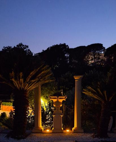 a group of columns and a fountain at night at M a i s o n - H e x a g o n Neoclassical Style in Riano
