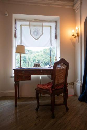 a desk with a chair in front of a window at M a i s o n - H e x a g o n Neoclassical Style in Riano