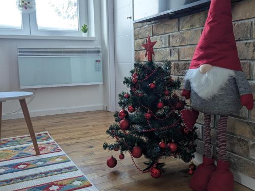 a santa claus is standing next to a christmas tree at Kopaonička priča in Kopaonik