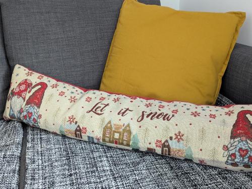 a pillow that says let it snow sitting on a couch at Kopaonička priča in Kopaonik