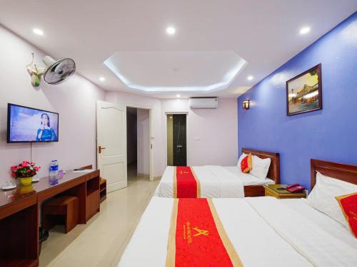 a hotel room with two beds and a tv at New An Phú Hotel in Dong Anh