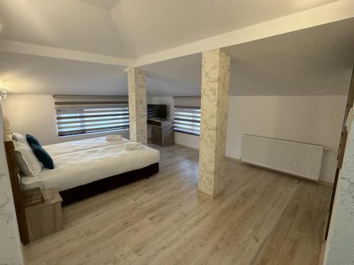 a large bedroom with a bed and wooden floors at Семеен хотел БОНЖУР in Panagyurishte