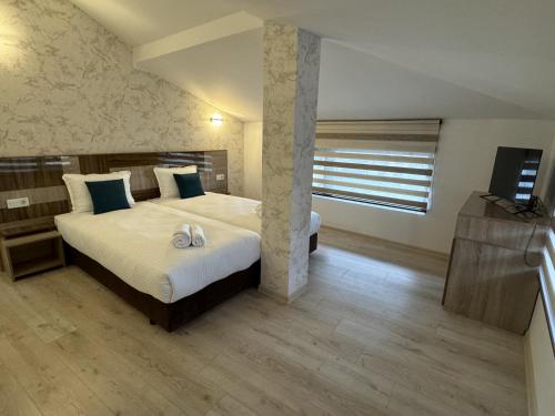 a bedroom with a large bed and a window at Семеен хотел БОНЖУР in Panagyurishte