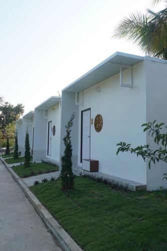 a white building with a door on the side of it at ห้างหุ้นส่วนจำกัด บ้านเถ้าแก่ in Ban Muang Baeng