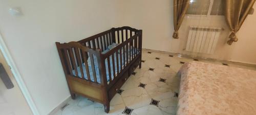 a crib in a room with a tiled floor at Jijel in Jijel