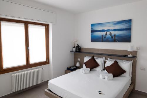 a bedroom with a large white bed and two windows at B&B I LAKE IT BELLAGIO in Bellagio