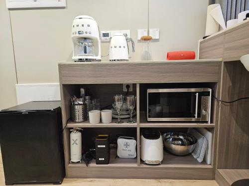 a kitchen cabinet with a microwave and some appliances at Forest Capsule in Uddevalla