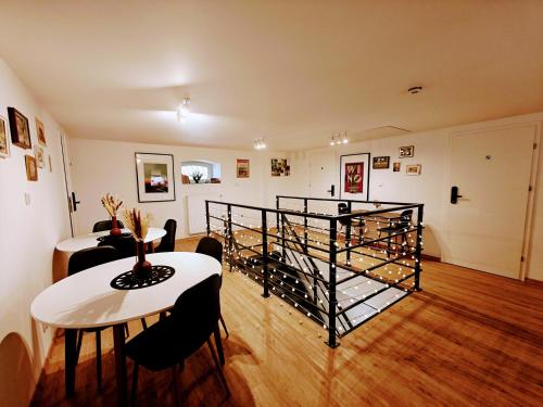 a living room with a table and a stair case at Winnica NOVI - apartamenty in Cianowice Duże
