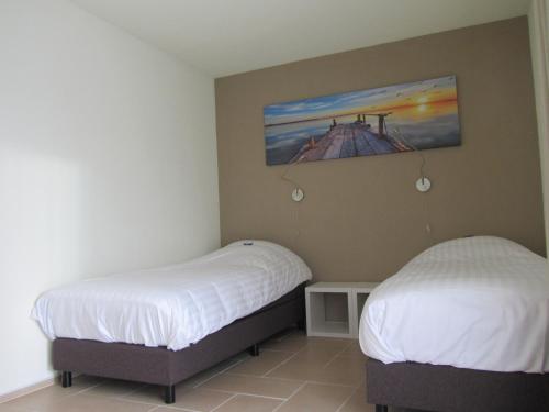 2 Betten in einem Zimmer mit Wandgemälde in der Unterkunft Hotel Garni Am Lindenhof Bunde in Bunde