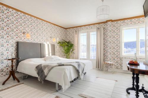 a bedroom with a large bed with floral wallpaper at Villa Bro in Brastad