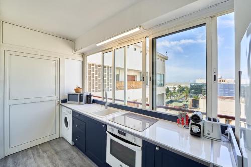 une cuisine avec un évier et une grande fenêtre dans l'établissement Nice Excepetional view, à Nice