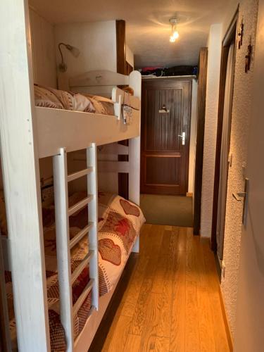 a small room with two bunk beds and a hallway at 2 pièces La Clusaz Centre village dans petite résidence in La Clusaz