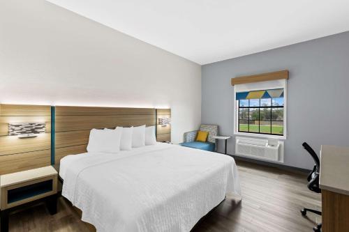 a hotel room with a bed and a window at Sonesta Essential Beaumont in Beaumont