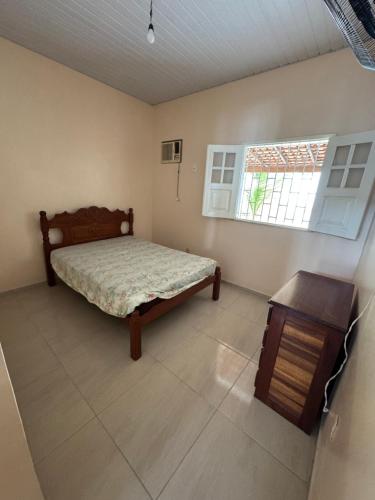 a bedroom with a bed and a table and a window at Salinas Atalaia in Salinópolis