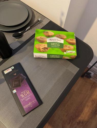 a box of bagels on a table next to a book at London House near Greenwich, Free Parking, Free WIFI in London
