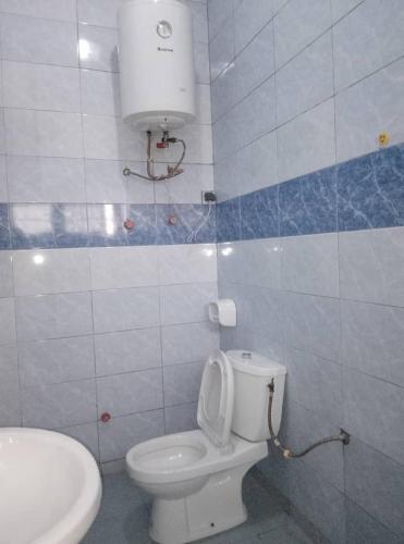 Un baño con un inodoro blanco y un lavabo. en LUXURY, en Cotonou