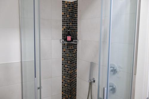 a shower with a glass door with a tile floor at B&B I LAKE IT BELLAGIO in Bellagio
