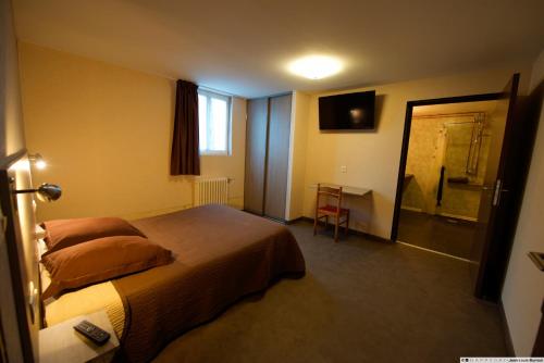 ein Hotelzimmer mit einem Bett, einem Schreibtisch und einem Fenster in der Unterkunft Hôtel La Tente Verte in Loon-Plage