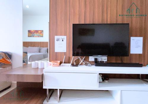 a living room with a tv on a white desk at Gurney Drive Mansion One Serviced Apartment in George Town