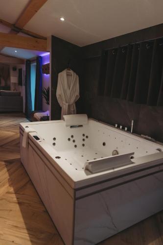 a bath tub in a room with a shirt hanging on a wall at L Atelier by VIP in Saint Die