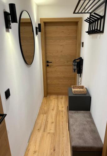 a hallway with a wooden door and a mirror at Alpen Studio Ellmau III in Ellmau