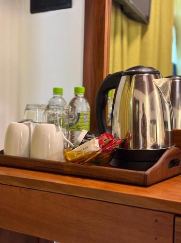 a tray with a tea kettle and cups on a counter at Chaya Beach Hotel,Tangalle in Tangalle