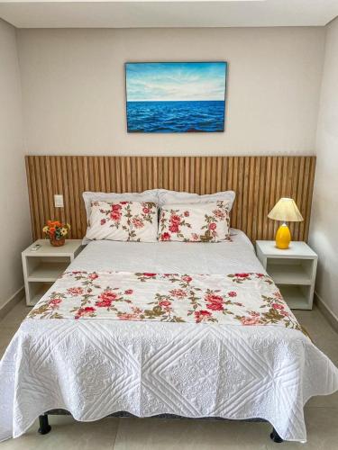a bedroom with a large bed with flowers on it at Recanto sol nascente in Rio Formoso