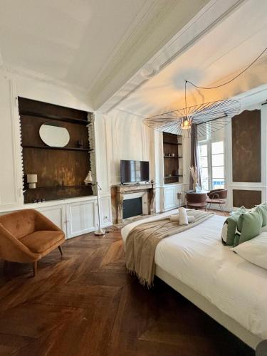 - une chambre avec 2 lits, une chaise et une cheminée dans l'établissement Les lices, centre ville de Rennes, à Rennes