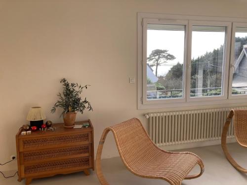 un salon avec deux chaises et une table et une fenêtre dans l'établissement Maison a Concarneau a 150m de la plage, à Concarneau