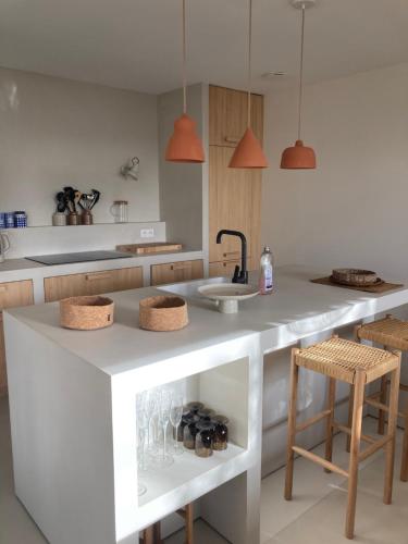 une cuisine avec un évier et un comptoir avec des chaises dans l'établissement Maison a Concarneau a 150m de la plage, à Concarneau