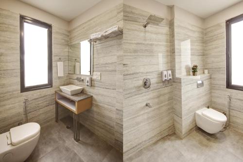 a bathroom with a toilet and a sink at Limewood Stay - Corporate Huda City Centre in Gurgaon