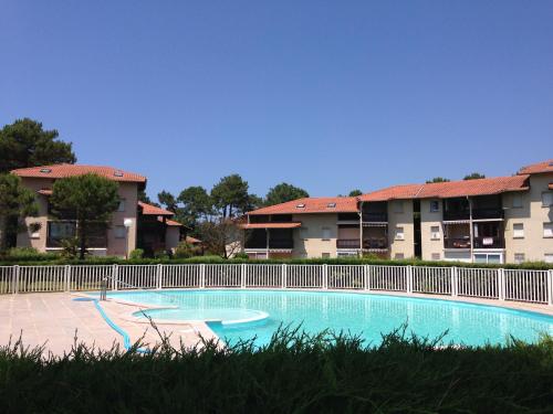 une piscine devant certains immeubles d'habitation dans l'établissement S-Plage 02-Soustons Joli petit appartement avec jardin et piscine pour 4 personnes, à Vieux-Boucau-les-Bains