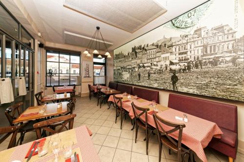 a restaurant with tables and chairs and a painting on the wall at Pied à Terre - Appart'hôtels au coeur d'Autun in Autun