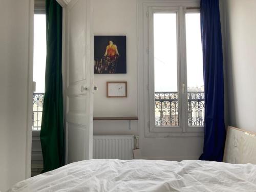une chambre avec un lit et une fenêtre avec vue dans l'établissement Luminous and inspiring arty home, à Paris