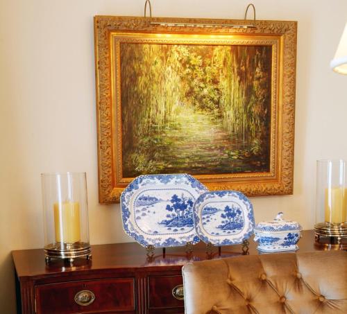 a painting on a wall with two chairs and two candles at Hotel Moliceiro in Aveiro