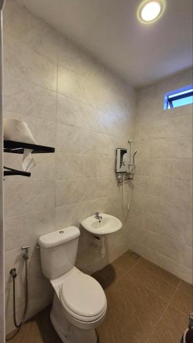 a bathroom with a toilet and a sink at KT Homestay in Jasin