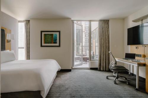 a hotel room with a bed and a desk with a computer at World Center Hotel in New York