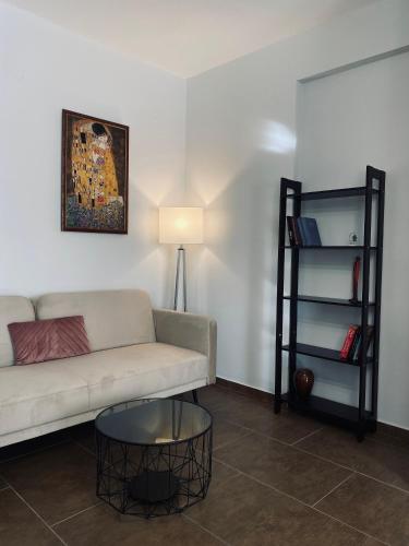 a living room with a couch and a table at Morfeas Apartment Ioannina in Anatolí