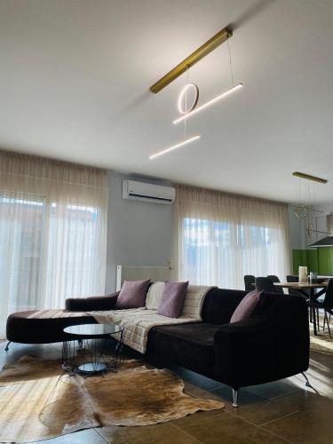a living room with a black couch and a table at Morfeas Apartment Ioannina in Anatolí