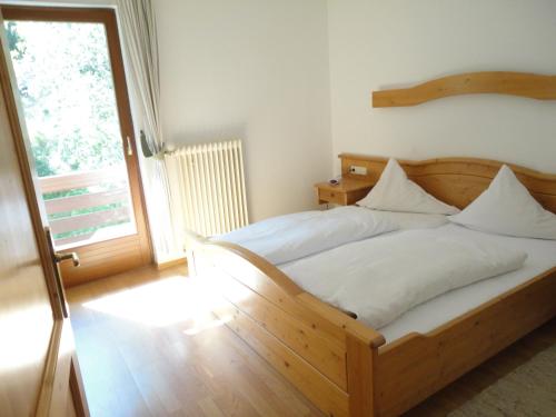 a wooden bed in a room with a window at Appartements Lärchenhof in Bad Kleinkirchheim
